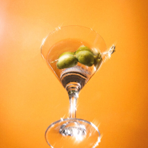 Martini with olives against a gold background at Aera in Toronto